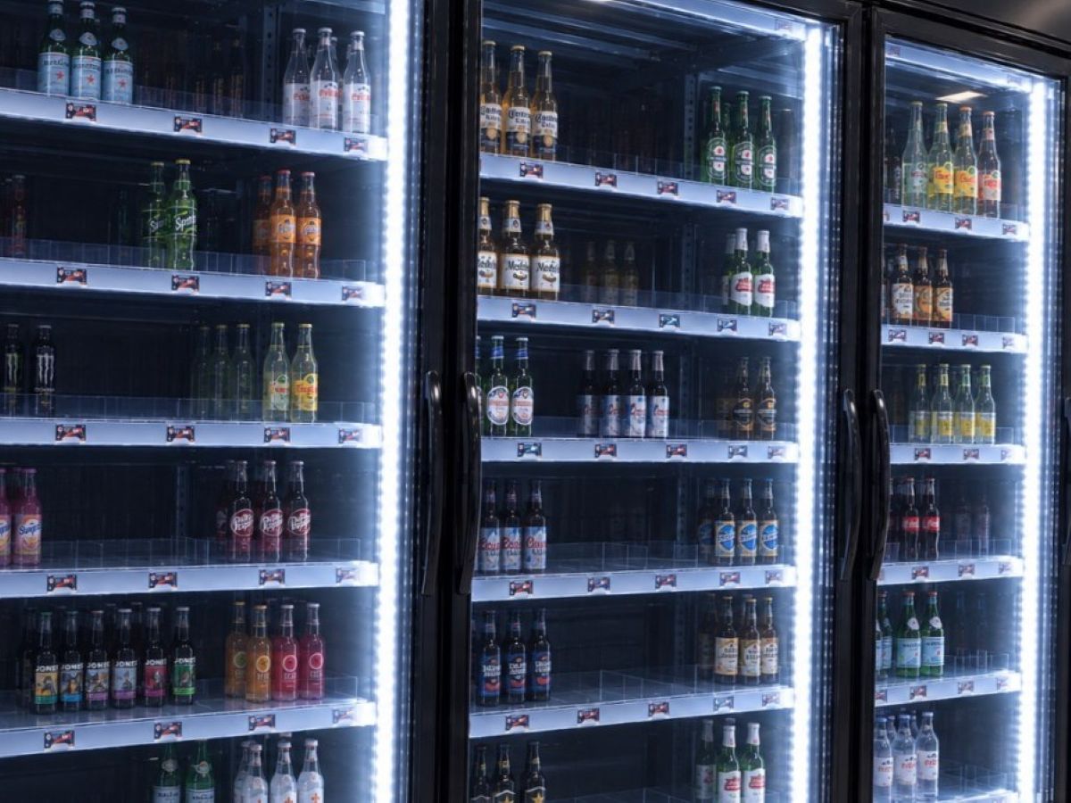 Antes: Estante de refrigerador desorganizado con stock atrás y botellas ocultas
